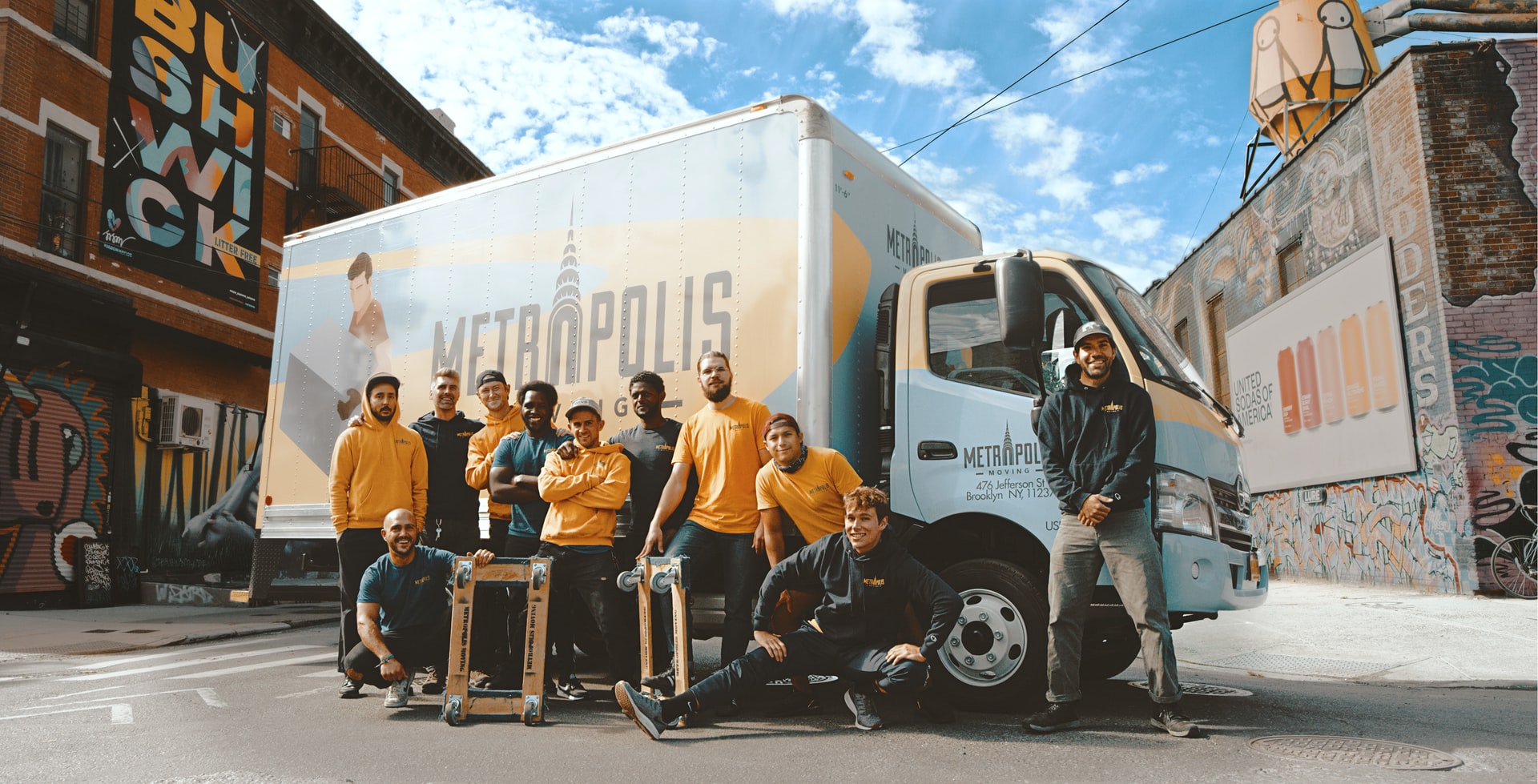 A team of movers standing in front of their truck