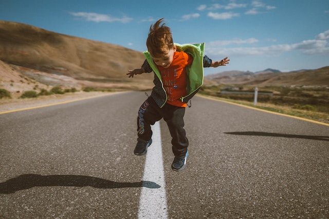 Child jumping on the road.