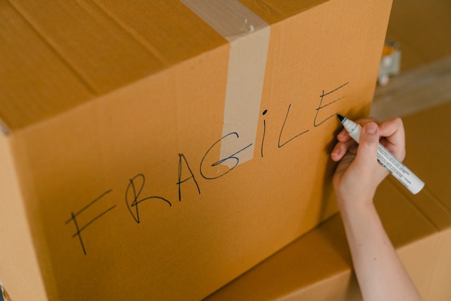 A person packing a box with fragile items.