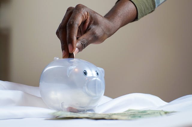 A person putting money in the piggy bank.