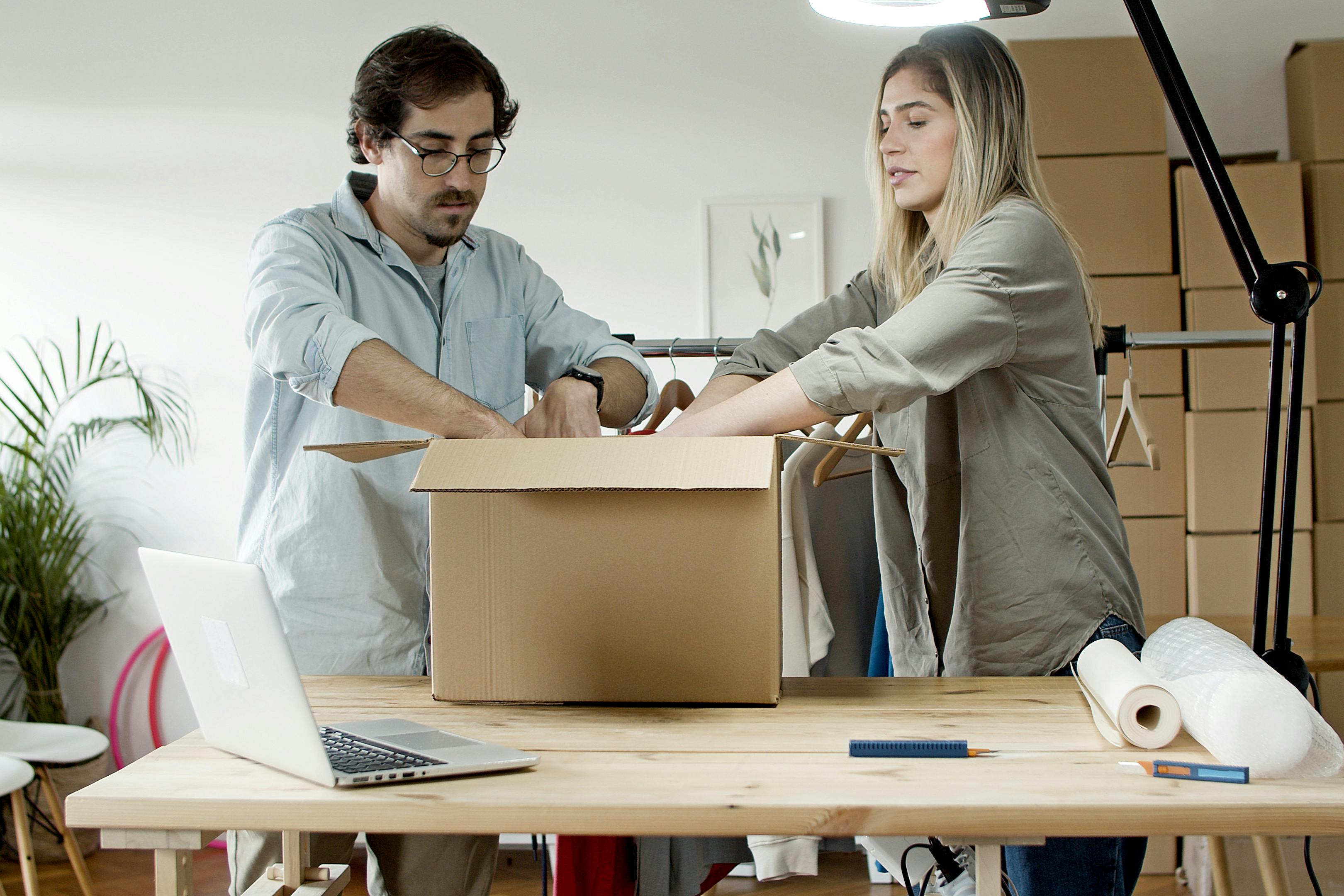 Two people packing a box